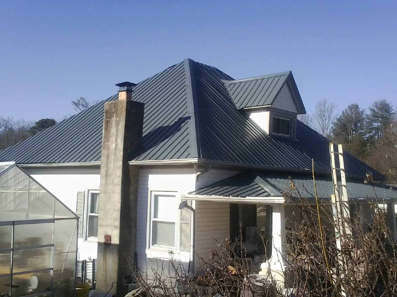 Dark blue standing seam metal roof on a white farmhouse with dormer — Slate & Tile Roof Repair by Roofing Brothers in Portola Valley