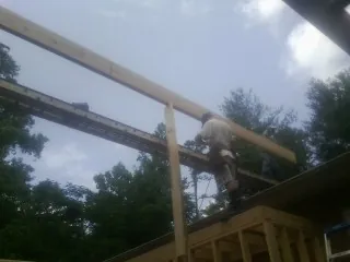 Carpenter setting a ridge beam over a new addition frame — Ice Dam Removal by Roofing Brothers in Portola Valley